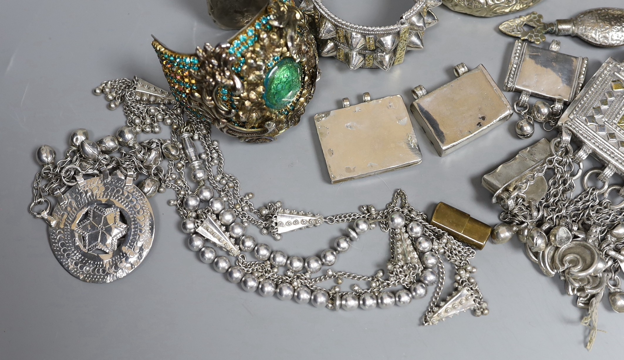 A small group of Middle Eastern mainly white metal jewellery, including bangles, bracelets and an Omani Hirz necklace.